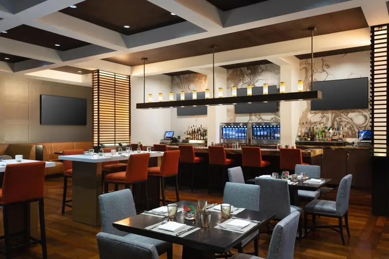 Une salle de restaurant moderne avec des tables et un comptoir de bar.