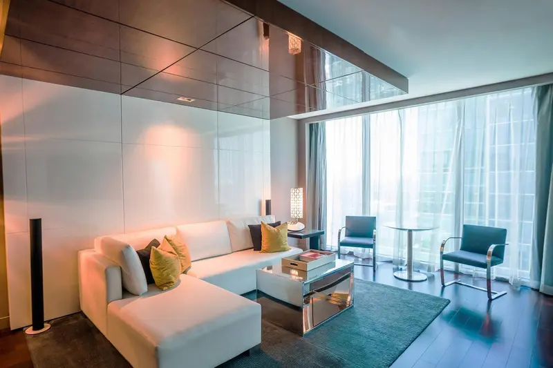 Un salon moderne avec canapé blanc, fauteuils et table basse.