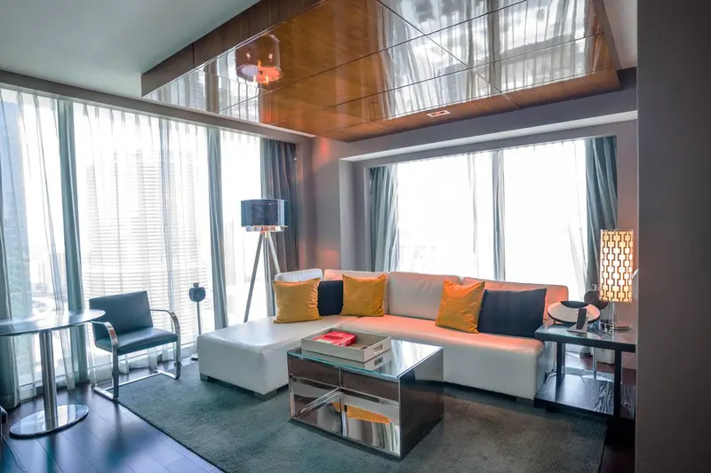Un salon moderne avec canapé d'angle, fauteuil et table basse.