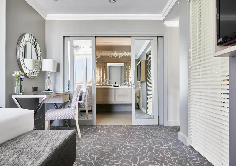 Une chambre d'hôtel moderne avec un coin bureau et une salle de bain attenante.