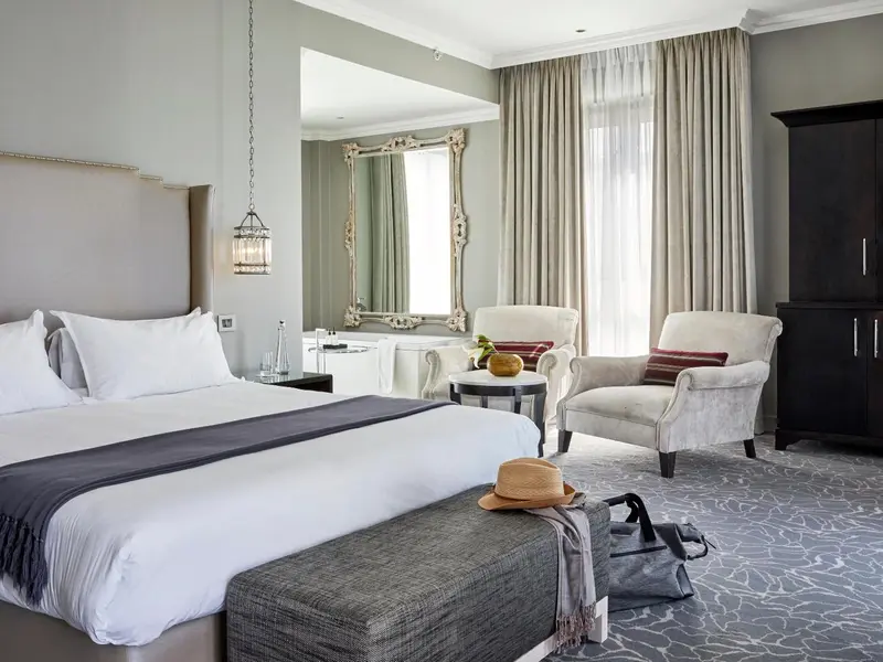 Une chambre lumineuse avec un grand lit et un coin salon.