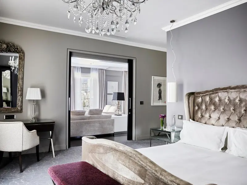 Une chambre élégante avec un grand lit et un espace salon attenant.