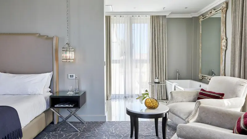 Une chambre lumineuse avec un lit et un coin salon.