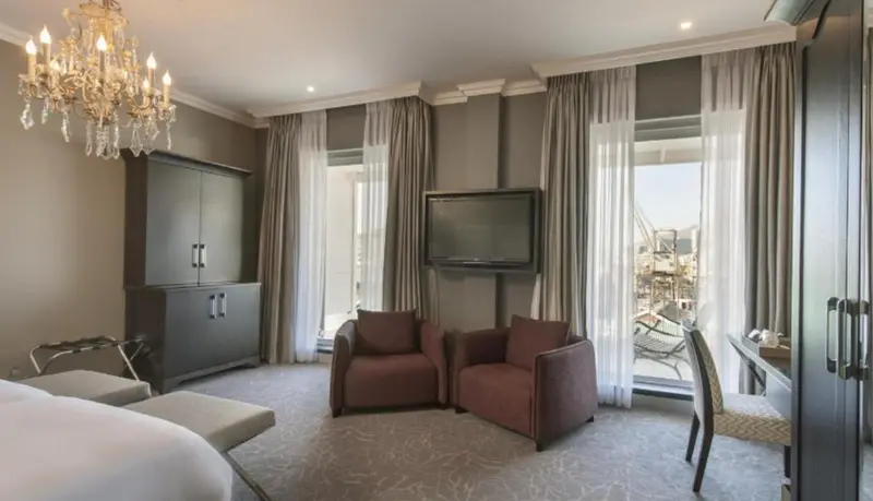 Une chambre d'hôtel élégante avec un coin salon et une télévision à écran plat.