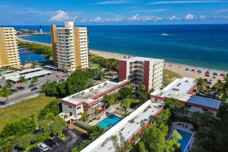 Vue aérienne d'un complexe hôtelier avec piscine et accès à la plage.