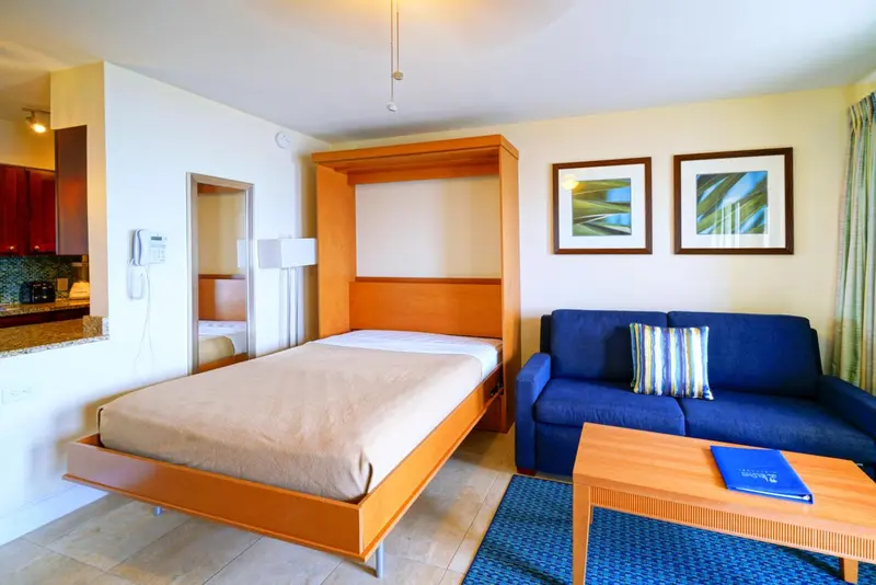 Une chambre avec un canapé et un coin cuisine.