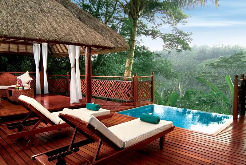 Terrasse en bois avec chaises longues et petite piscine.