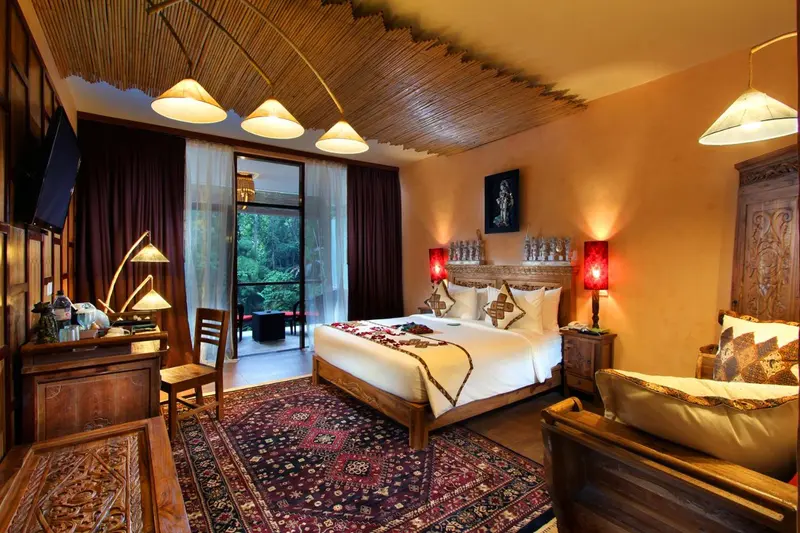 Une chambre décorée avec un lit à baldaquin et un accès à une terrasse.