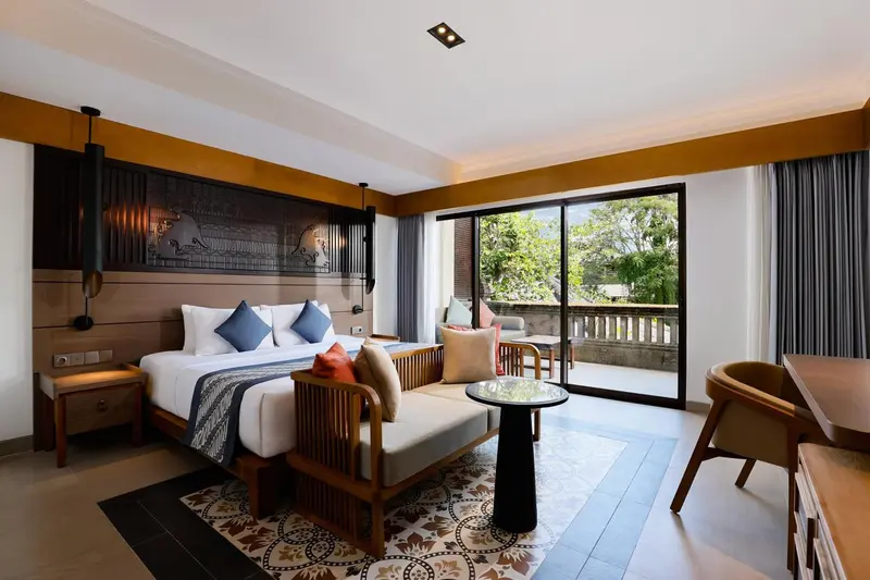 Chambre lumineuse avec un grand lit et un espace détente.