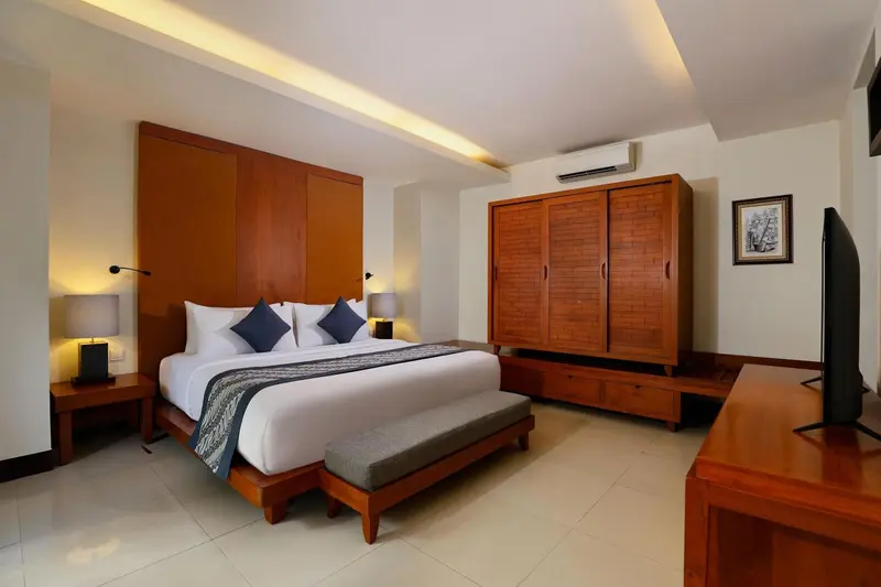 Une chambre lumineuse avec un grand lit et un mobilier en bois.