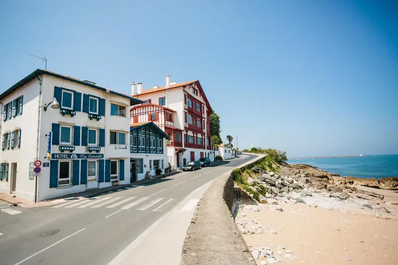 Façades de bâtiments colorés le long d'une route côtière ensoleillée.