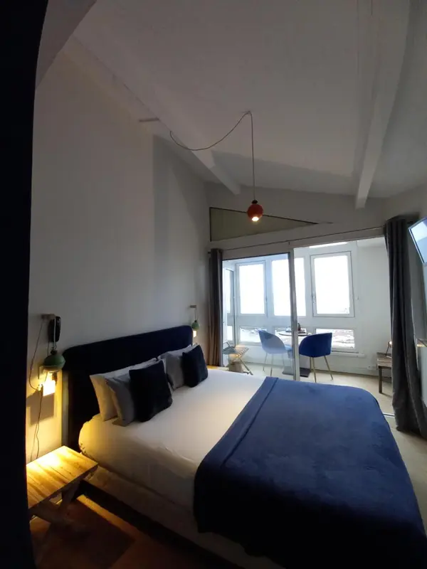 Une chambre lumineuse avec un grand lit et un accès à une terrasse.