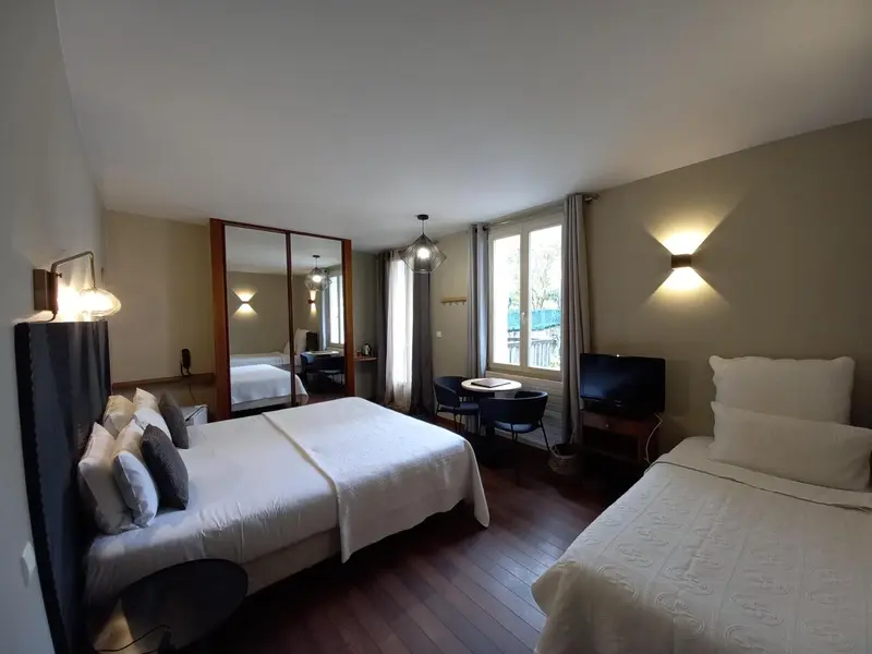 Une chambre lumineuse avec un grand lit et un coin salon.