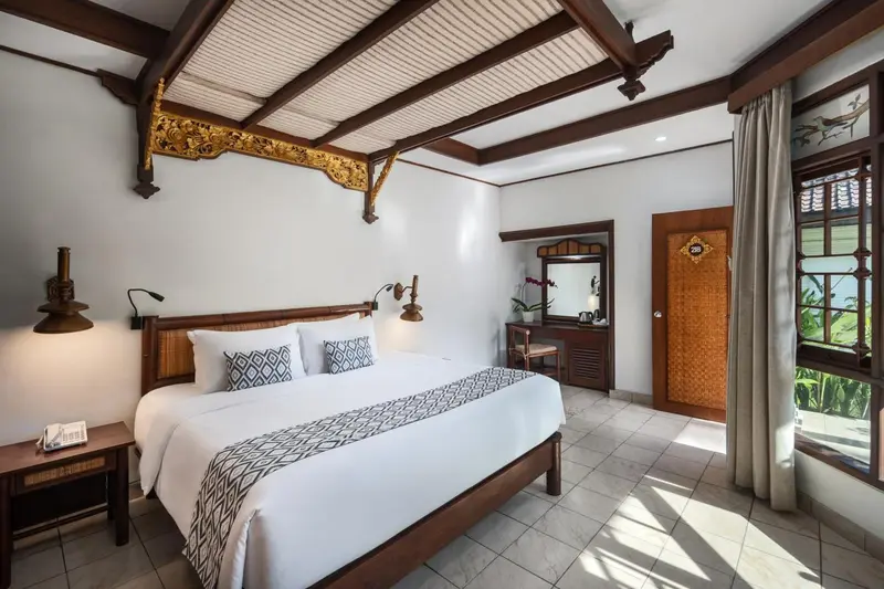 Une chambre lumineuse avec un grand lit recouvert d'une courtepointe à motifs.