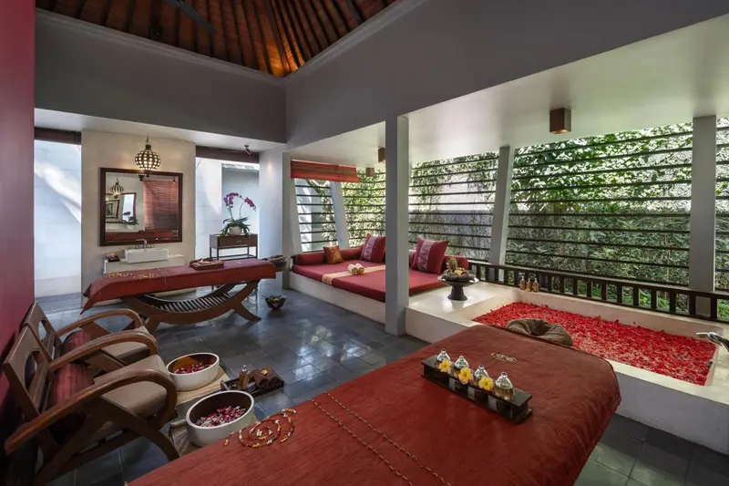 Espace de relaxation avec tables de massage et décorations florales.