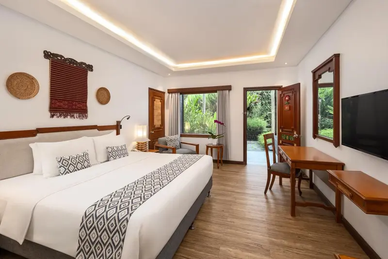 Une chambre lumineuse avec un grand lit et un bureau.