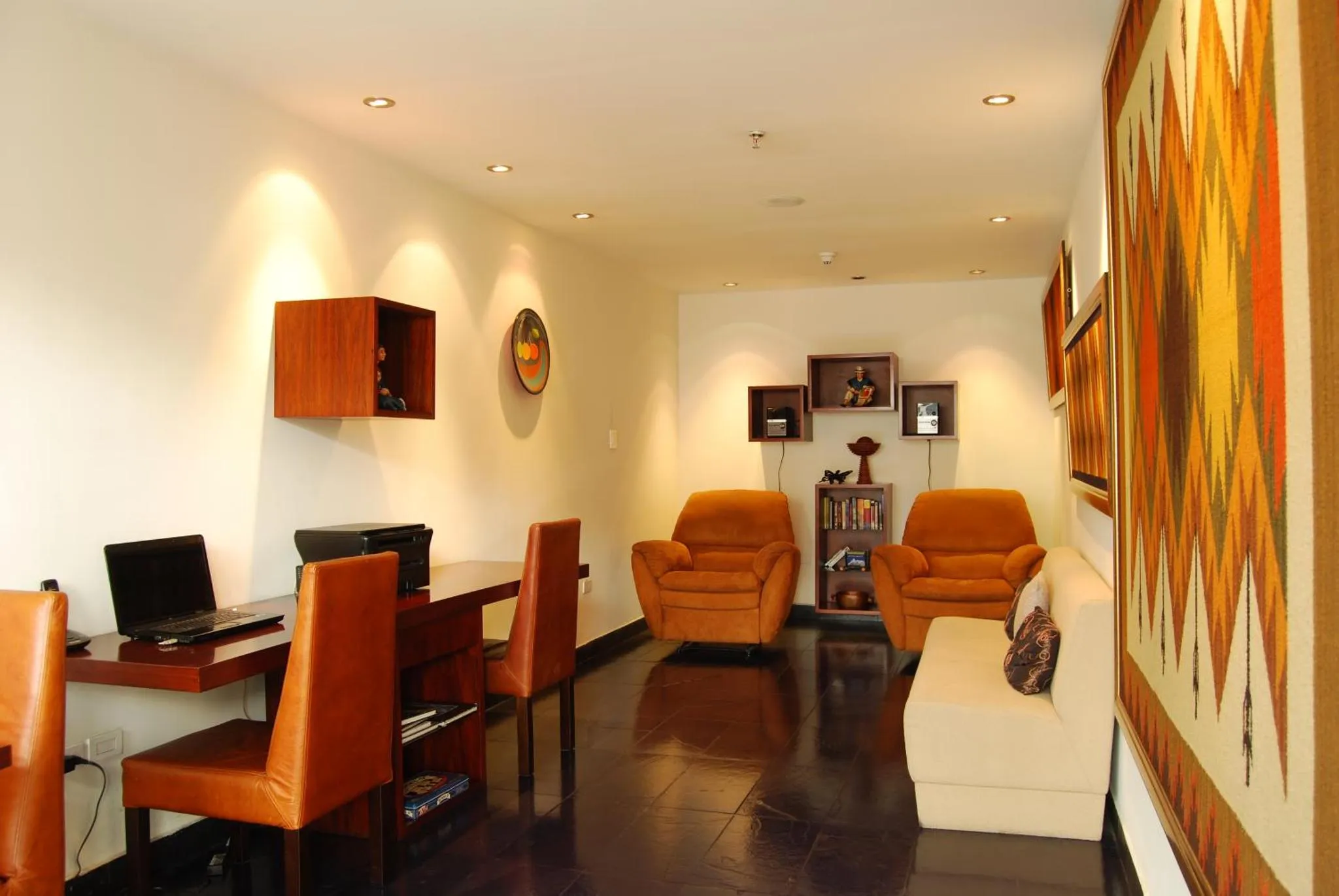 Espace de détente avec fauteuils, bureau et décoration murale.