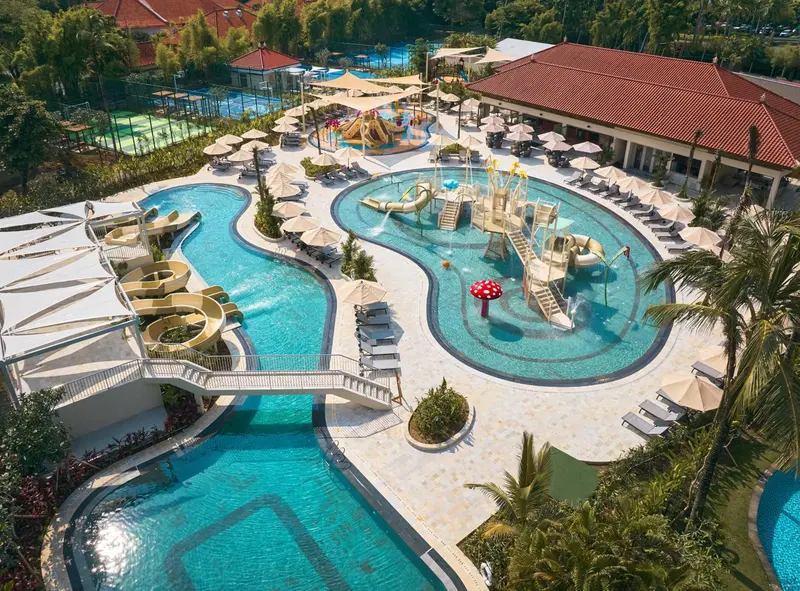 Vue aérienne d'un complexe aquatique avec des piscines sinueuses et des jeux d'eau.