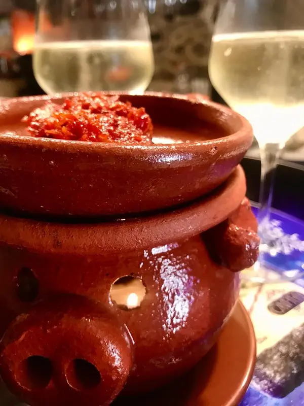 Un plat de crevettes servi dans un récipient en céramique décoré.