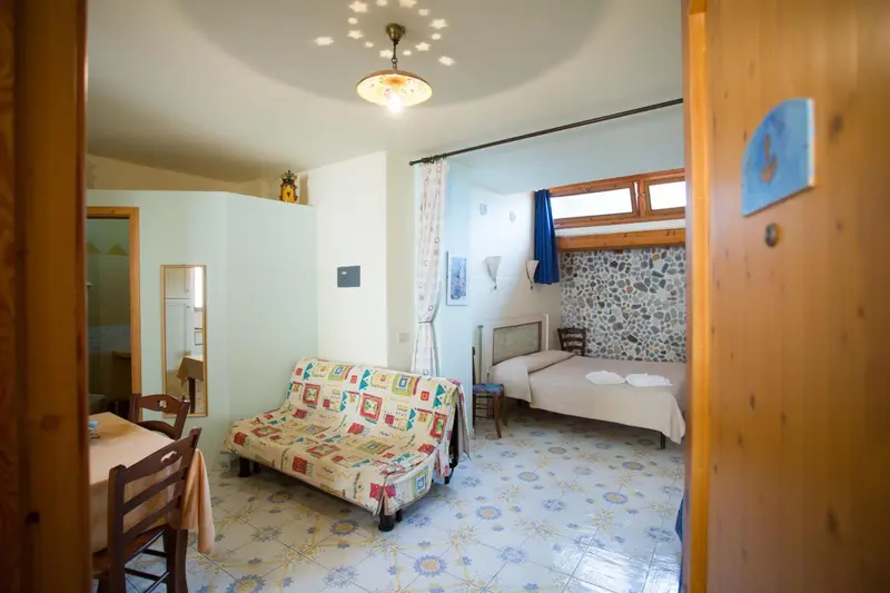 Une chambre lumineuse avec un canapé et un lit simple.