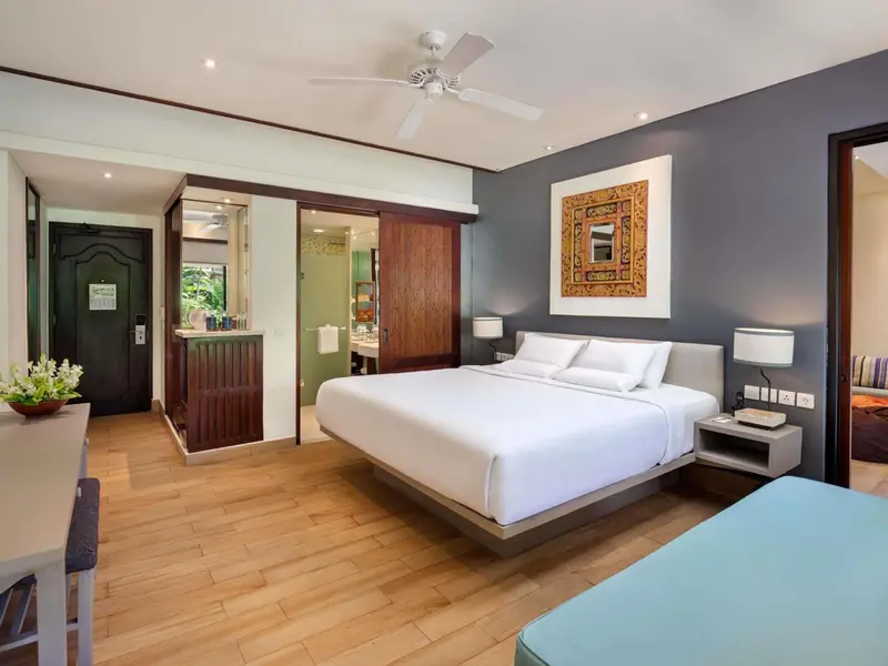 Une chambre lumineuse avec un grand lit et un espace détente.