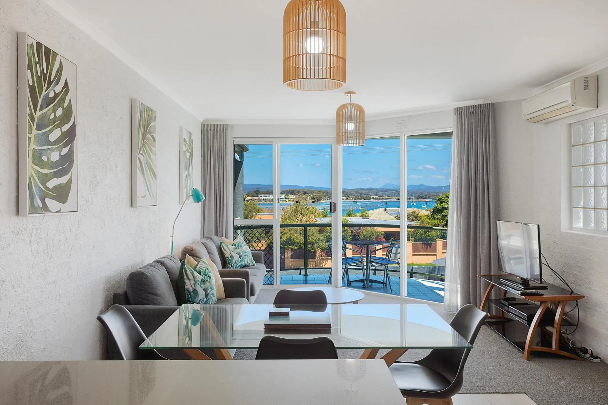 Un salon lumineux s'ouvre sur une terrasse avec vue sur la mer.