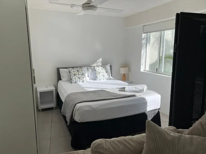 Une chambre lumineuse avec un grand lit et une décoration sobre.