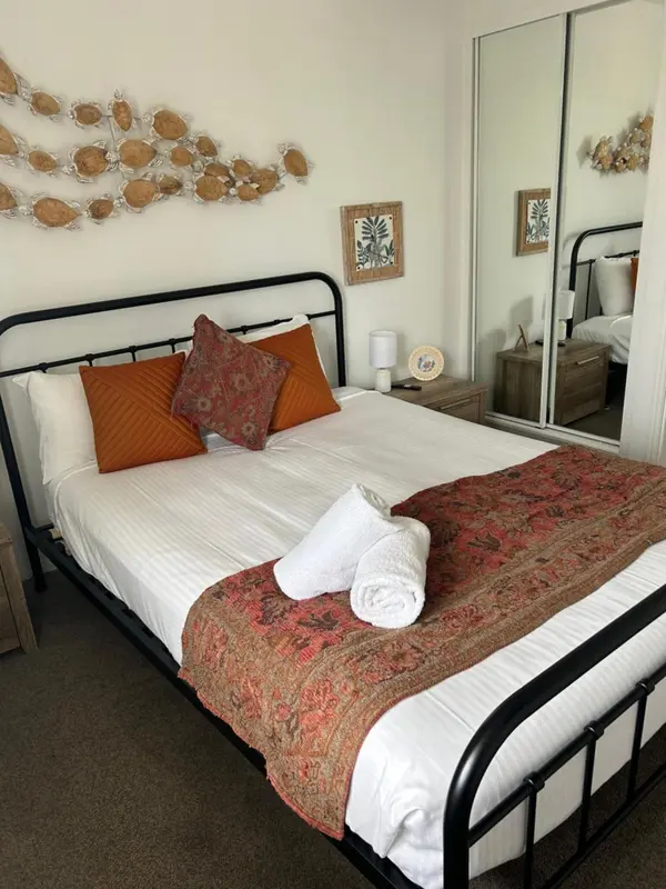 Une chambre avec un lit recouvert d'une courtepointe et de coussins.