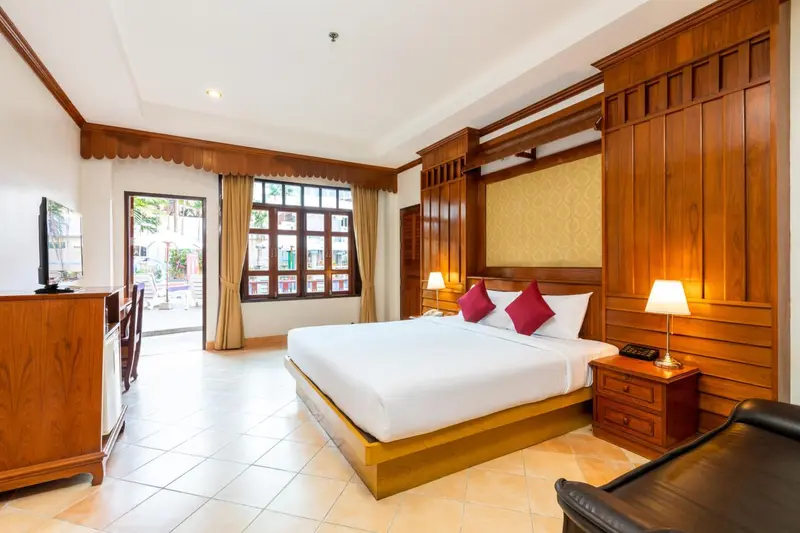 Une chambre lumineuse avec un grand lit et un mobilier en bois.