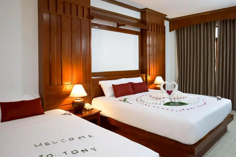 Une chambre lumineuse avec deux lits décorés de fleurs et de serviettes.
