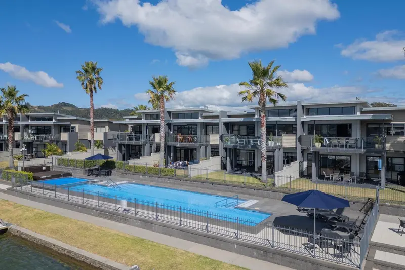 Vue aérienne d'un complexe hôtelier avec piscine et palmiers.