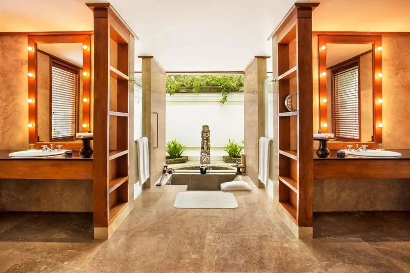 Une salle de bain lumineuse avec deux vasques et une baignoire extérieure.