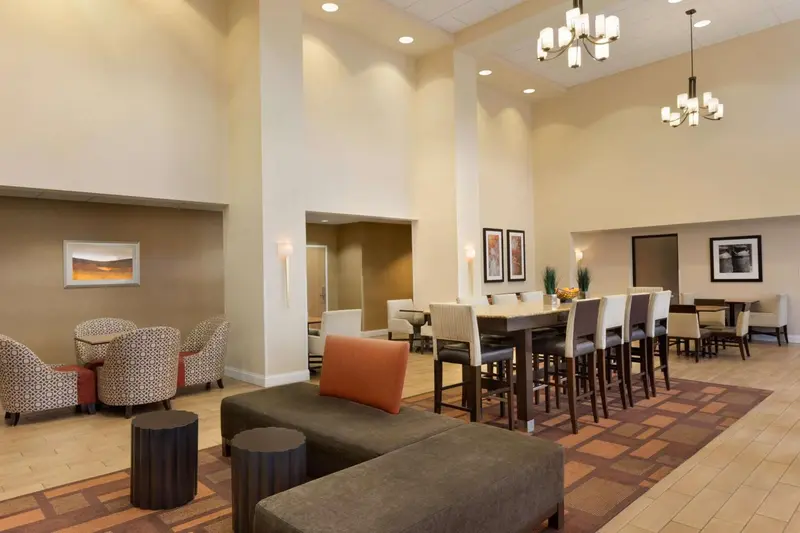 Espace de détente avec canapés, fauteuils et tables basses dans un hall d'hôtel.
