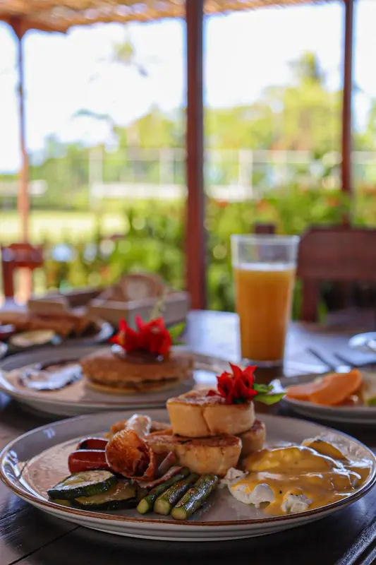 Une table est dressée avec un petit-déjeuner copieux et une boisson fraîche.
