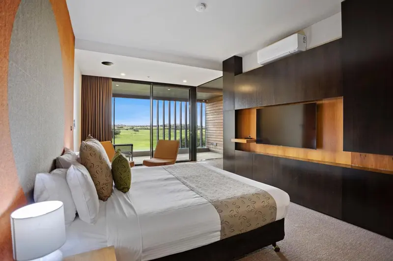 Une chambre lumineuse avec un grand lit et une vue sur un paysage verdoyant.