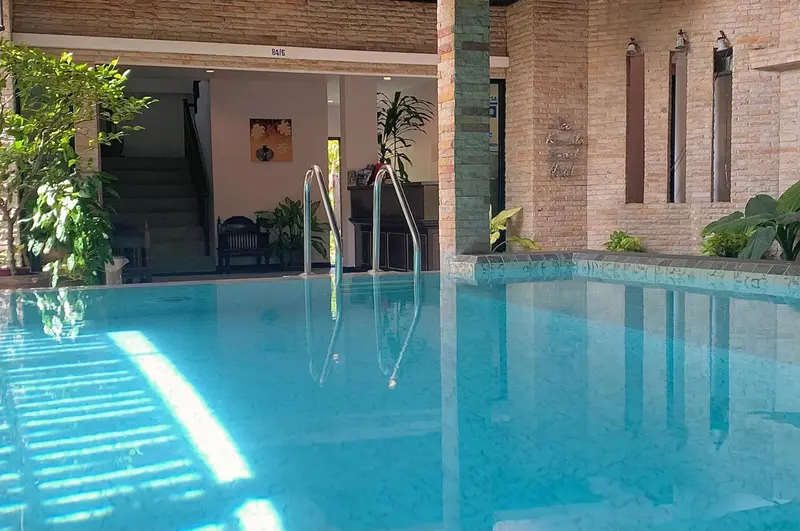 Une piscine turquoise reflète l'architecture environnante et la végétation luxuriante.