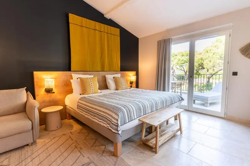 Une chambre lumineuse avec un grand lit et un accès à une terrasse.