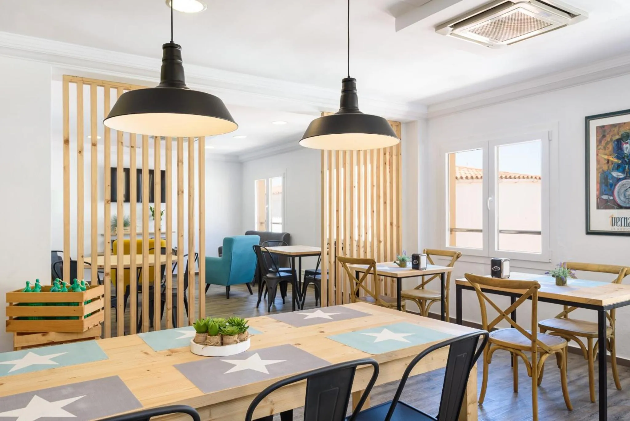 Une salle lumineuse avec des tables et des chaises en bois.