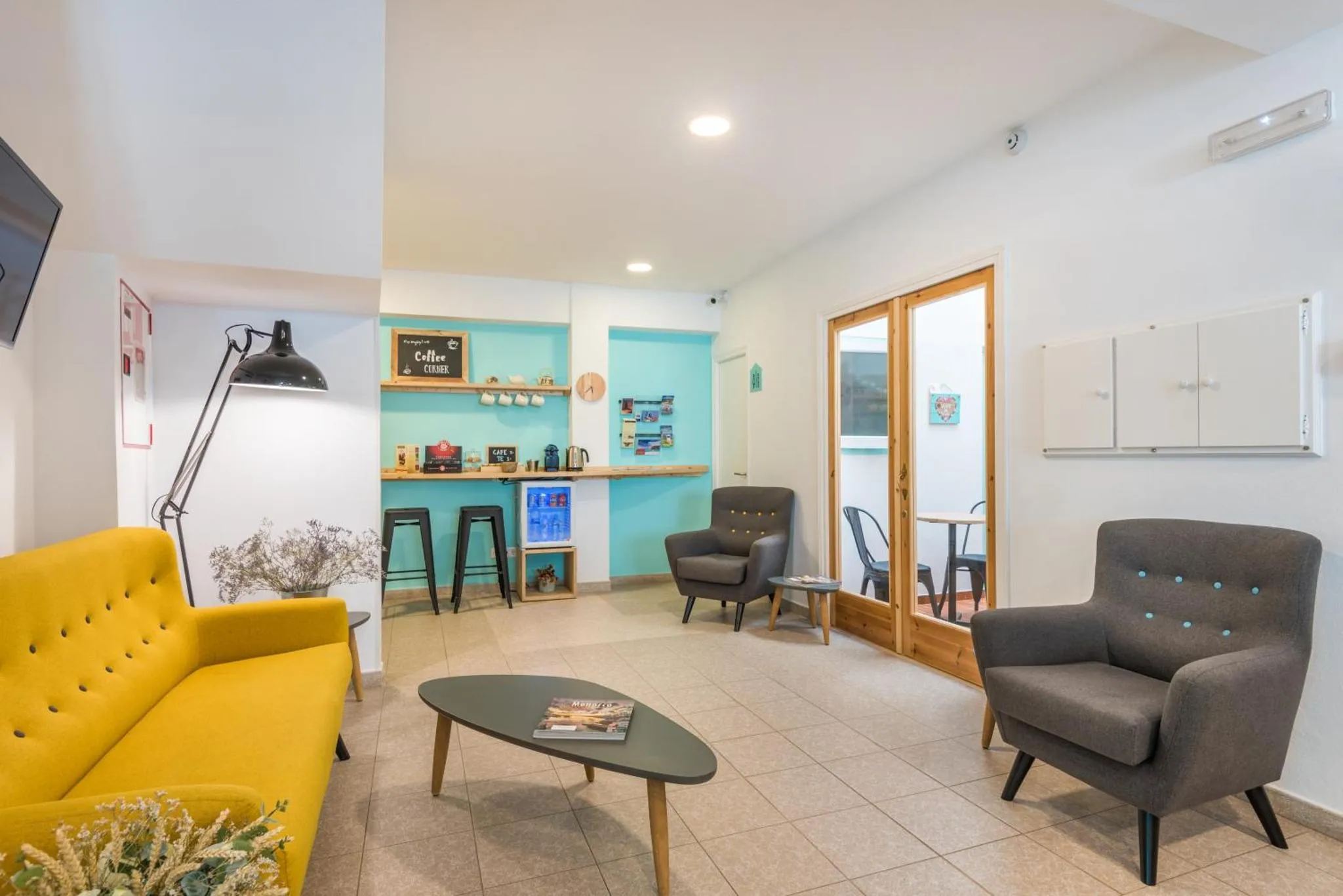 Un espace de détente intérieur avec canapés et fauteuils est aménagé avec une table basse et un coin café.