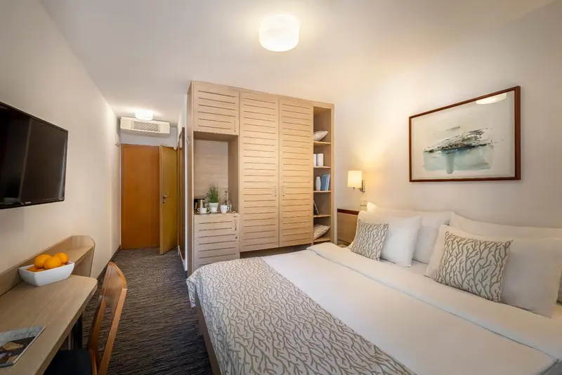 Une chambre lumineuse avec un lit double et un grand placard.