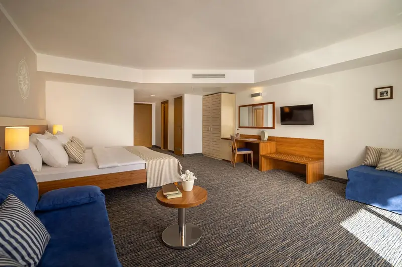 Une chambre lumineuse avec un grand lit et un coin salon.