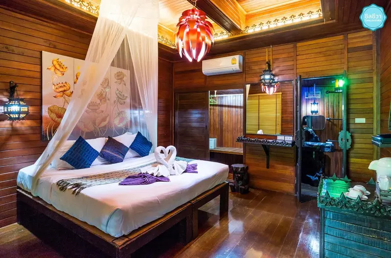 Une chambre avec un grand lit à baldaquin et une décoration en bois sculpté.