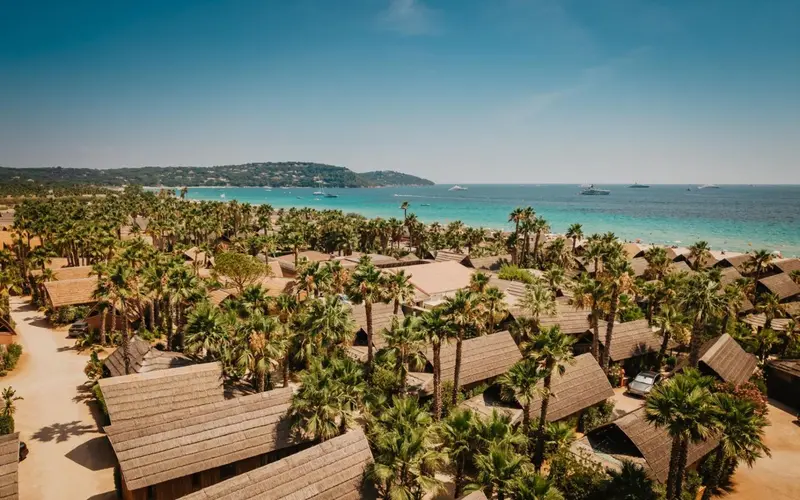 Vue aérienne d'un complexe hôtelier bordant une plage de sable fin et une mer turquoise.