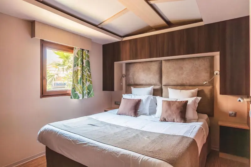 Une chambre lumineuse avec un grand lit et des coussins décoratifs.