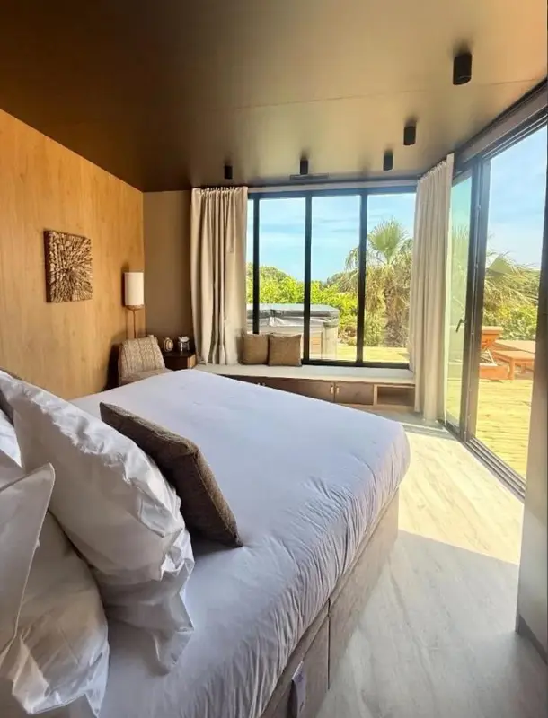 Une chambre lumineuse avec un grand lit et un accès à une terrasse.