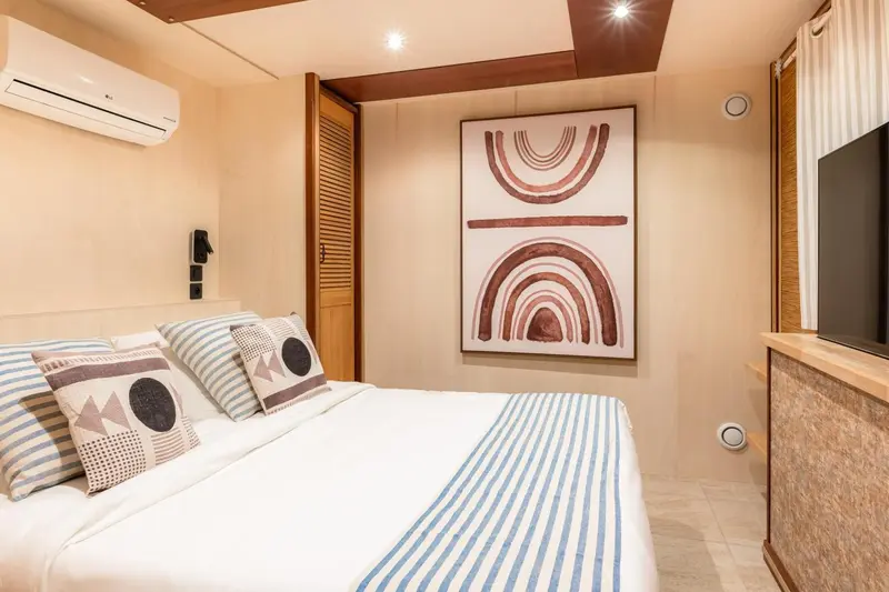 Une chambre lumineuse avec un lit recouvert d'une courtepointe à rayures.
