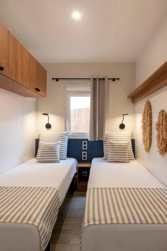 Deux lits simples dans une chambre décorée de manière sobre.