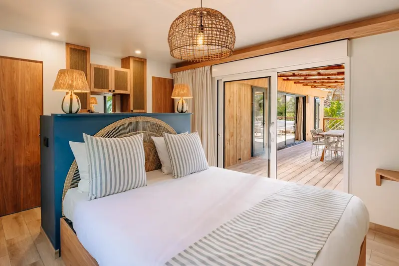 Une chambre lumineuse avec un grand lit et un accès à une terrasse.