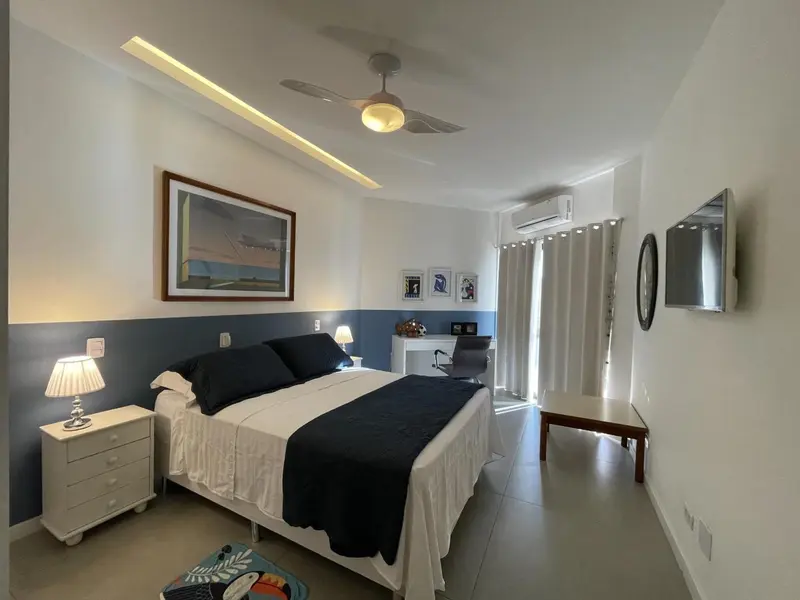 Une chambre lumineuse avec un lit double et un bureau.