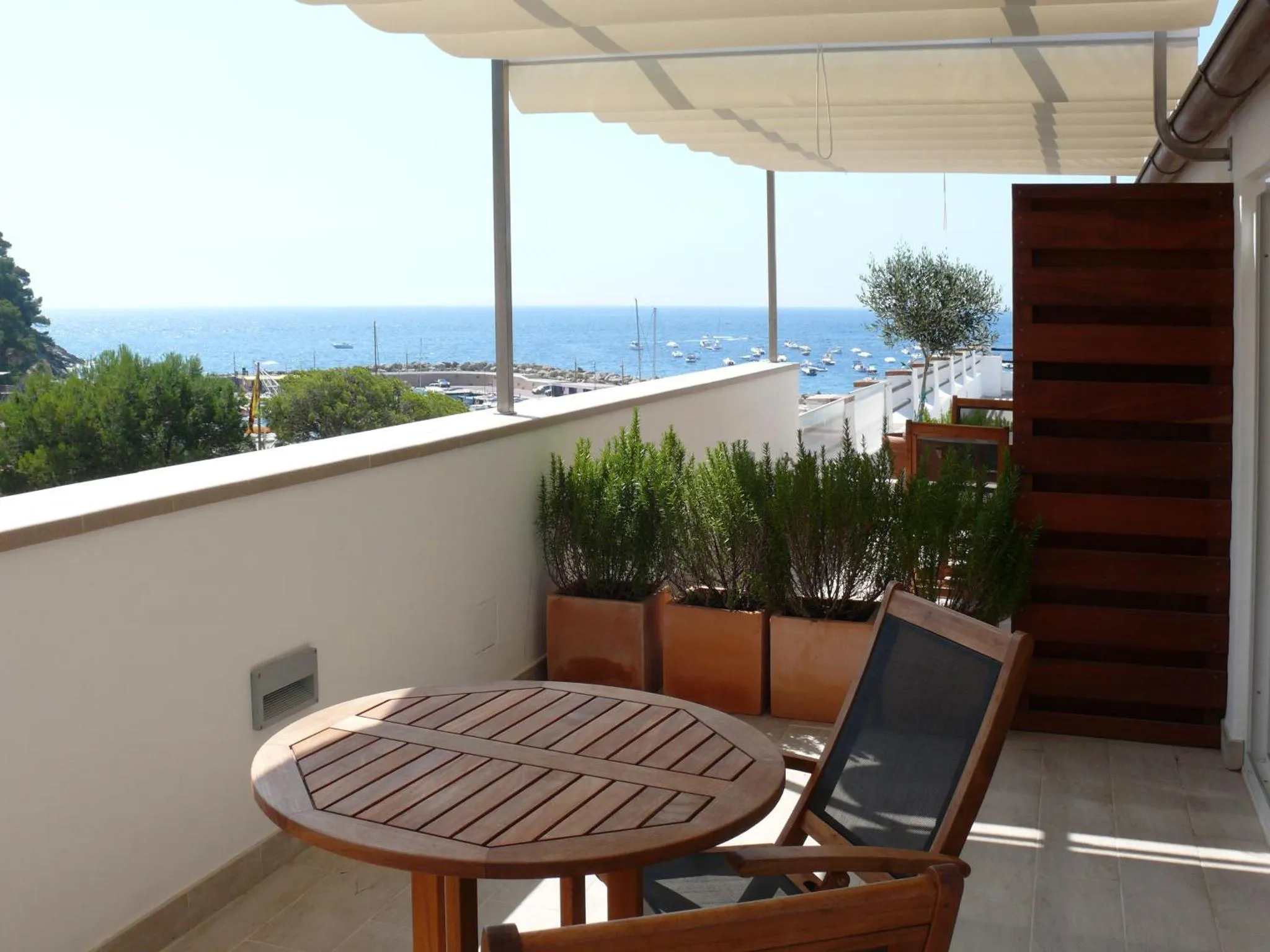 Terrasse avec table ronde et vue sur la mer.